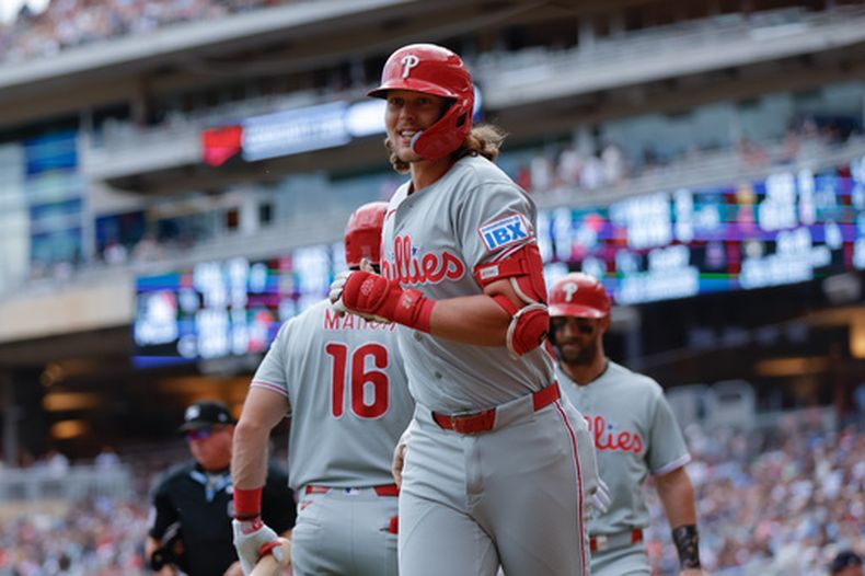 El antesalista de los Filis de Filadelfia, Alec Bohm (centro), celebra tras conectar un jonrón de tres carreras durante la sexta entrada de un partido de béisbol contra los Mellizos de Minnesota, el domingo 16 de agosto de 2026, en Minneapolis. (Foto AP/Bailey Hillesheim)