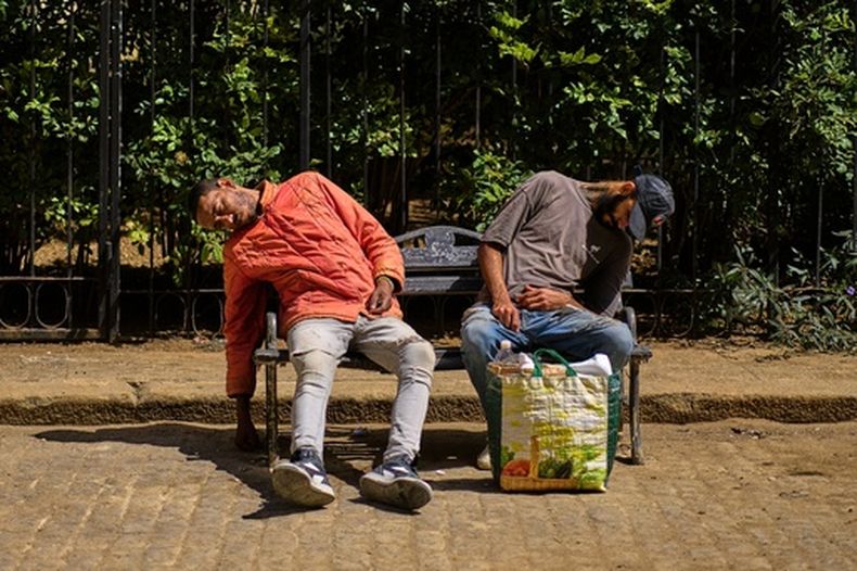 Personas bajo la influencia de sustancias desconocidas duermen en un banco afuera de una iglesia donde ocasionalmente reciben alimentos donados en La Habana, Cuba, el martes 24 de febrero de 2026. (AP Foto/Ramón Espinosa)