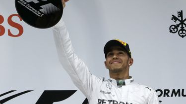 americateve | El brit&aacute;nico Lewis Hamilton, de Mercedes, levanta en el podio el trofeo de ganador de la carrera del Gran Premio de Formula Uno en el Circuito Internacional de Shanghai, el domingo 20 de abril de 2014. (AP Foto/Alexander F. Yuan)