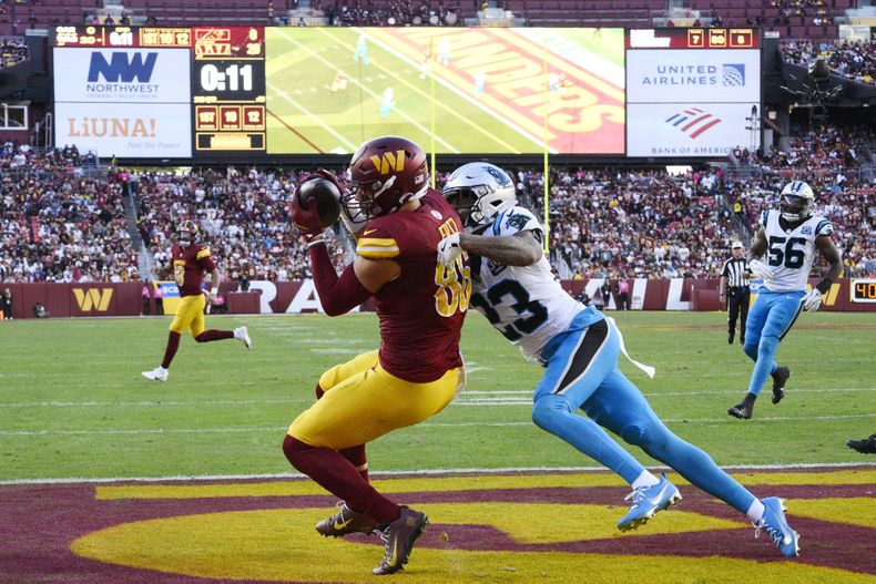 Zach Ertz (86) tight end de los Commanders de Washington, atrapa un pase de anotación de 12 yardas frente a Dane Jackson (23), de los Panthers de Carolina, el domingo 20 de octubre de 2024, en Landover, Maryland. (AP Foto/Nick Wass)