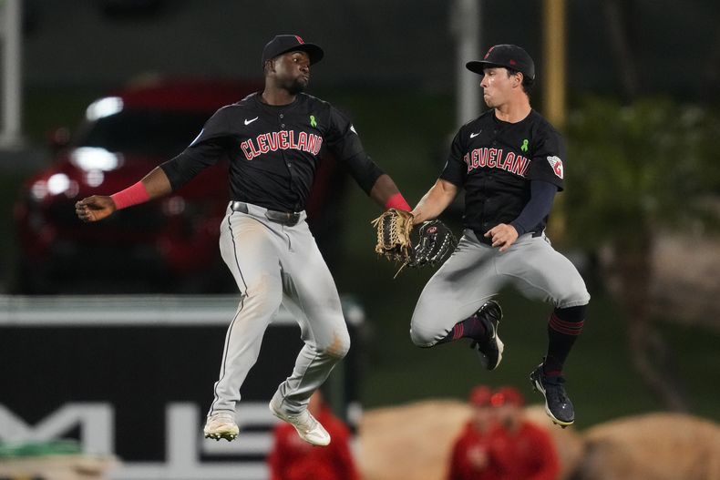 El jardinero izquierdo de los Guardianes de Cleveland, Estevan Florial, la izquierda, y el jardinero derecho Will Brennan celebran después de una victoria por 4-3 sobre los Angelinos de Los Ángeles en el juego de béisbol en Anaheim, California, el sábado 25 de mayo de 2024. (AP Foto/Ashley Landis)