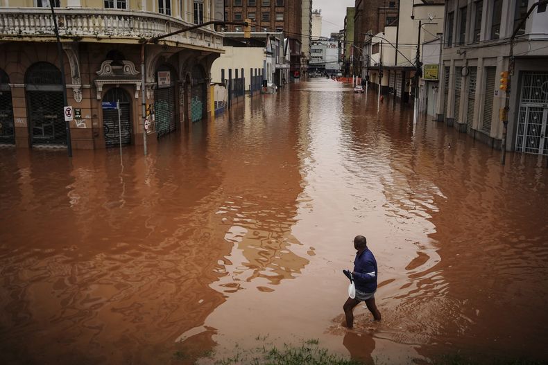 Un hombre camina por una calle inundada debido a las intensas lluvias, el viernes 3 de mayo de 2024, en Porto Alegre, estado de Río Grande do Sul, Brasil. (AP Foto/Carlos Macedo)