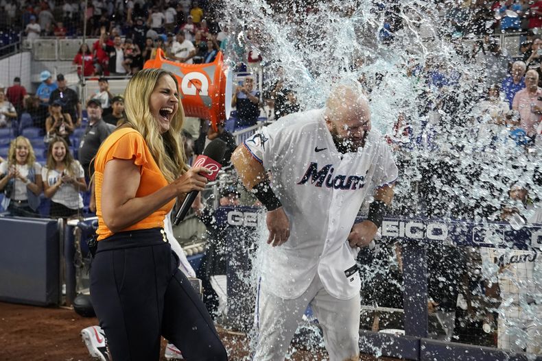 Jake Burger de los Marlins de Miami recibe un baño de Gatorade tras remolcar la carrera de la victoria ante los Yanquis de Nueva York por 8-7, el domingo 13 de agosto de 2023, en Miami. (AP Foto/Marta Lavandier)
