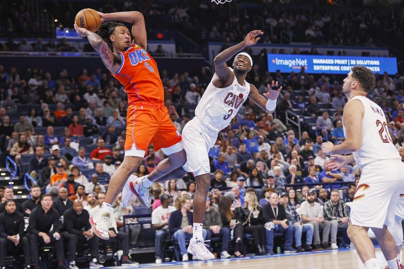 Jaylin Williams, del Thunder de Oklahoma City, atrapa un rebote frente a Caris LeVert (3) y Georges Niang, de los Cavaliers de Cleveland, el miércoles 8 de noviembre de 2023 (AP foto/Nate Billings)