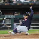 Josh Naylor, de los Guardianes de Cleveland, se desliza para anotar frente al cátcher mexicano Seby Zavala, de los Medias Blancas de Chicago, el jueves 27 de julio de 2023 (AP Foto/Erin Hooley)