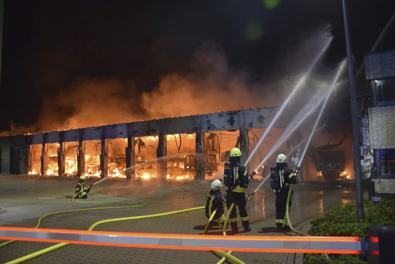 Bomberos tratan de extinguir un incendio en un depósito de vehículos en Stadtallendorf, Alemania, el miércoles 16 de octubre de 2024. (Michael Rinde/dpa via AP)