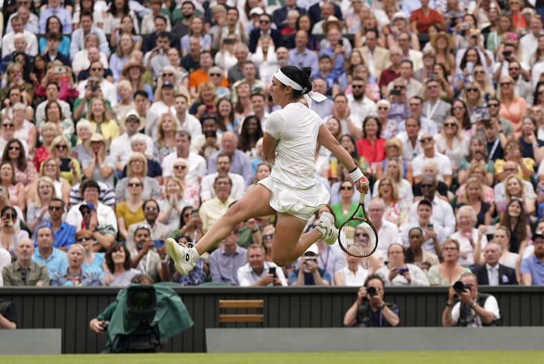 Ons Jabeur patea la pelota tras no poder devolver una volea de Aryna Sabalenka en las semifinales del torneo de Wimbledon, el jueves 13 de julio de 2023, en Londres. (AP Foto/Alberto Pezzali)