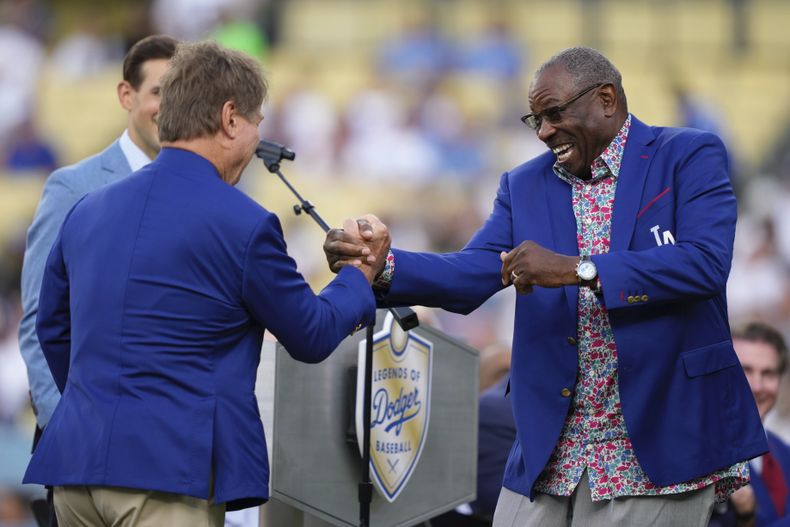 Ron Cey, izquierda, exintegrante de los Dodgers de Los Ángeles es felicitado por Dusty Baker al ser inducido entre las Leyendas de los Dodgers previo al partido de béisbol de Grandes Ligas entre los Dodgers y los Cerveceros de Milwaukee el viernes 18 de julio de 2025, en Los Ángeles. (AP Foto/Mark J. Terrill)