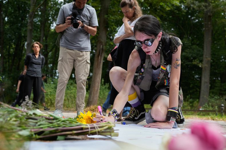 Ashley Jump coloca flores cerca del lugar del ataque al evento del Orgullo en Berlín, el 26 de julio del 2026. (AP foto/Markus Schreiber)