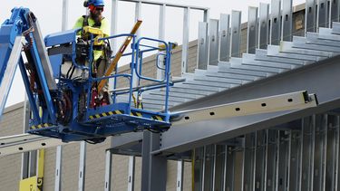 Un trabajador de la construcción maneja una grúa afuera de un sitio de construcción comercial en Mount Prospect, Illinois, el martes 27 de agosto de 2024. (AP Foto/Nam Y. Huh)