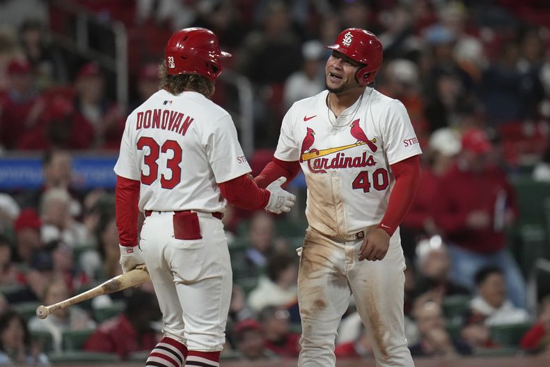 Willson Contreras (40), de los Cardenales de San Luis, es felicitado por su compañero de equipo Brendan Donovan después de anotar durante la quinta entrada del juego de béisbol contra los Astros de Houston el lunes 14 de abril de 2025, en San Luis. (AP Foto/Jeff Roberson)