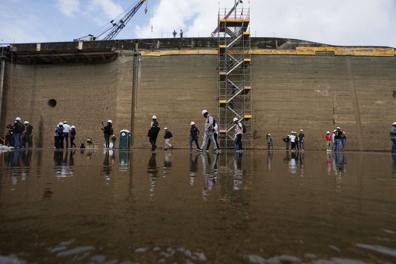 Funcionarios del Canal de Panamá y periodistas caminan por la esclusa Pedro Miguel en una operación rutinaria de mantenimiento en Ciudad de Panamá, el viernes 30 de mayo de 2025. (AP Foto/Matías Delacroix)