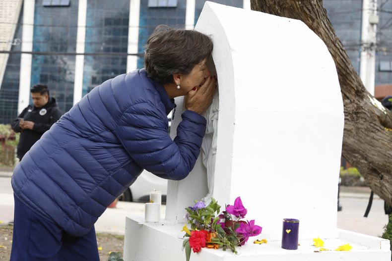 Una mujer reza en un altar construido en el lugar donde el senador opositor Miguel Uribe fue atacado a tiros durante un mitin político después del anuncio de su muerte, en Bogotá, Colombia, el lunes 11 de agosto de 2025. (AP Foto/John Wilson Vizcaino)