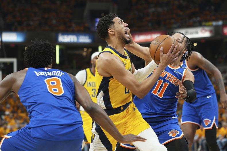Tyrese Haliburton, centro, busca atacar la canasta contra OG Anunoby (8) y Jalen Brunson (11), de los Knicks de Nueva York, durante la primera mitar del tercer juego de las finales de la Conferencia Este del baloncesto de la NBA, el domingo 25 de mayo de 2025, en Indianápolis. (AP Foto/AJ Mast)