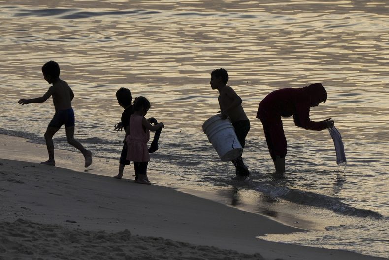 Palestinos visitan la playa de Deir al Balah, en la Franja de Gaza, en el segundo día del cese del fuego entre Israel y Hamás, el sábado 25 de noviembre de 2023. (AP Foto/Hatem Moussa)
