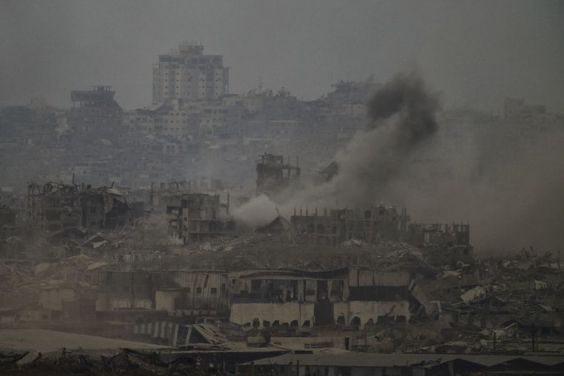 Humo se eleva entre edificios destruidos tras un bombardeo israelí en la Franja de Gaza, visto desde el sur de Israel, el viernes 1 de agosto de 2025. (AP Foto/Leo Correa)