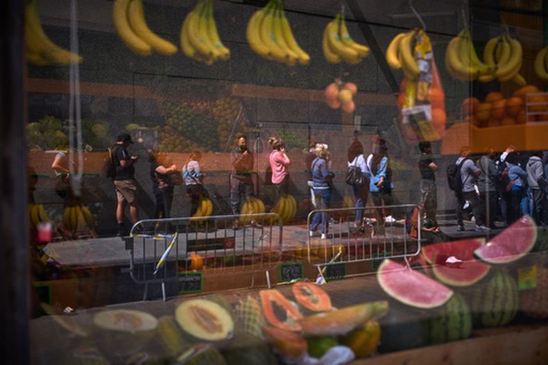 Migrantes hacen fila afuera del ayuntamiento de Barcelona, España, para regularizar sus papeles, el 20 de abril del 2026. (AP foto/Emilio Morenatti)