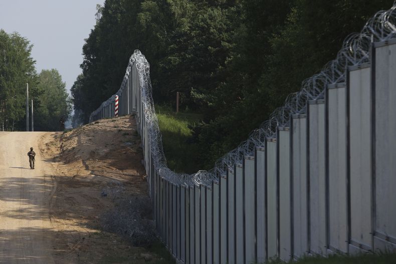 ARCHIVO - Un guardia fronterizo polaco vigila una zona de la frontera entre Polonia y Bielorrusia, cerca de Kuznice, Polonia, el 30 de junio de 2022. (AP Foto/Michal Dyjuk, Archivo)