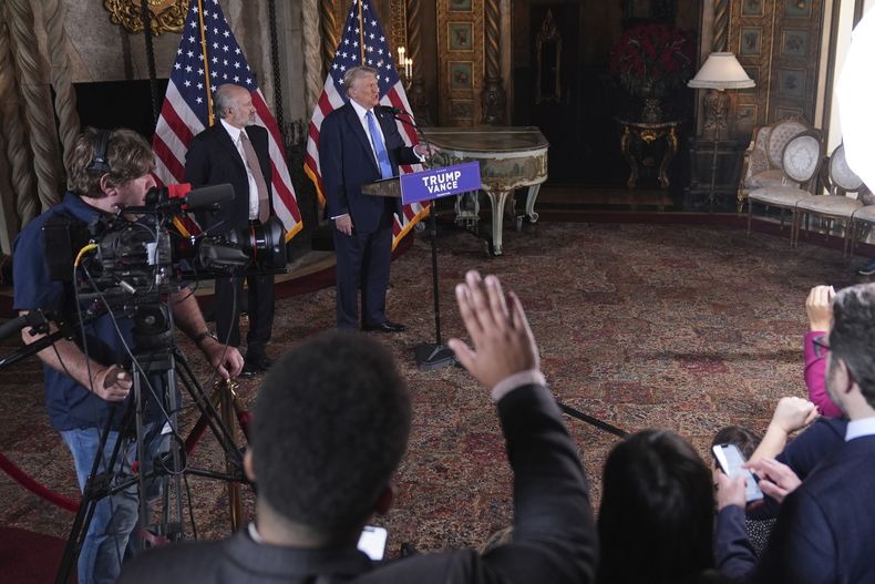 El presidente electo de Estados Unidos, Donald Trump, habla en una conferencia de prensa en Mar-a-Lago, el lunes 16 de diciembre de 2024, en Palm Beach, Florida, acompañado por el nominado a secretario de Comercio, Howard Lutnick. (AP Foto/Evan Vucci)