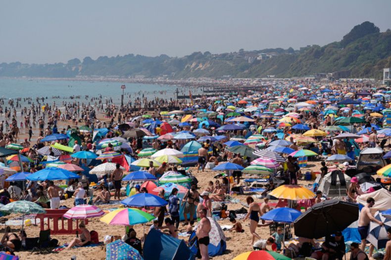 Gente en la playa de Bournemouth, en el sur de Inglaterra, el lunes 25 de mayo de 2026.(Andrew Matthews/PA via AP)