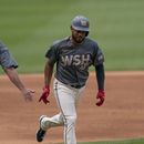 Jeimer Candelario de los Nacionales de Washington celebra con el entrenador de tercera base Gary Disarcina tras pegar un jonrón en la primera entrada en el juego ante los Rangers de Texas el sábado 8 de julio del 2023. (AP Foto/Stephanie Scarbrough)