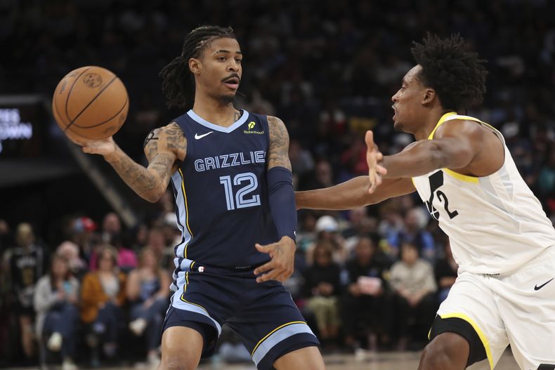 El base de los Grizzlies de Memphis Ja Morant pasa el balón frente al base del Jazz de Utah Colllin Sexton en el encuentro del miércoles 12 de marzo del 2025. (AP Foto/Nikki Boertman)