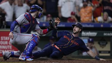 Kyle Tucker de los Astros de Houston anota la carrera de la victoria superando al catcher de los Rangers de Texas Jonah Heim tras el sencillo del dominicano Yainer Díaz en el encuentro del lunes 24 de junio del 2023. (AP Foto/Kevin M. Cox)