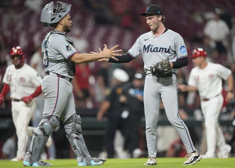 El pitcher Josh Simpson (derecha) y el receptor Agustín Ramírez celebran la victoria de los Marlins de Miami ante los Rojos de Cincinnati, el martes 8 de julio de 2025. (AP Foto/Carolyn Kaster)