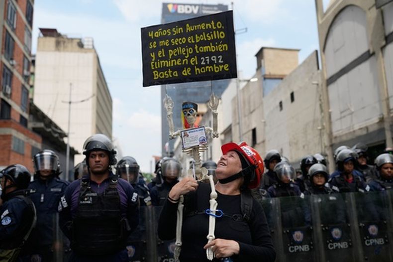 Una mujer participa en una protesta exigiendo mejores salarios, pensiones y beneficios, cerca de la Asamblea Nacional en Caracas, Venezuela, el jueves 12 de marzo de 2026. (Foto AP/Ariana Cubillos)