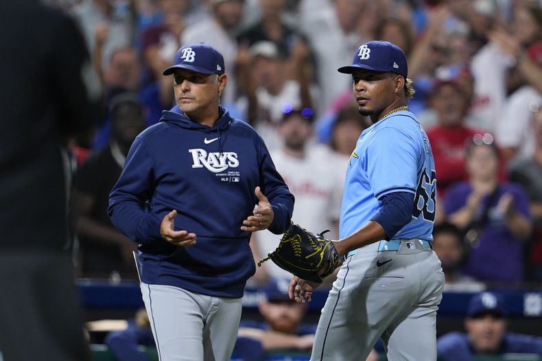 Edwin Uceta, derecha, de los Rays de Tampa Bay, camina hacia afuera del diamante después de haber sido expulsado por golpear a Nick Castellanos de los Filis de Filadelfia durante la octava entrada del juego de béisbol, el martes 10 de septiembre de 2024, en Filadelfia. (AP Foto/Derik Hamilton)