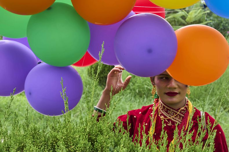 Un participante sostiene globos en el desfile del orgullo gay en Katmandú, Nepal, el 10 de agosto del 2025. (AP foto/Niranjan Shrestha)