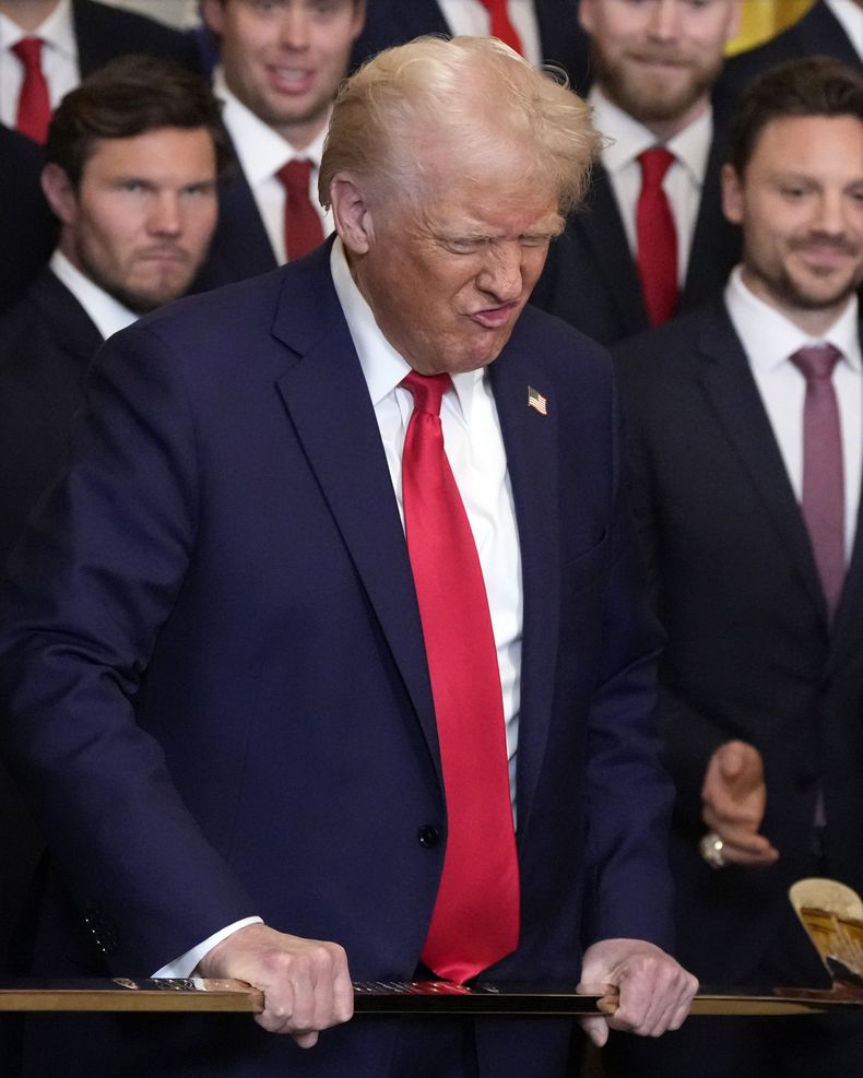 El presidente estadounidense Donald Trump hace un gesto al sostener un palo de hockey durante una ceremonia con los Panther de Florida en la Casa Blanca, el lunes 3 de febrero de 2025, en Washington. (AP Foto/Alex Brandon)
