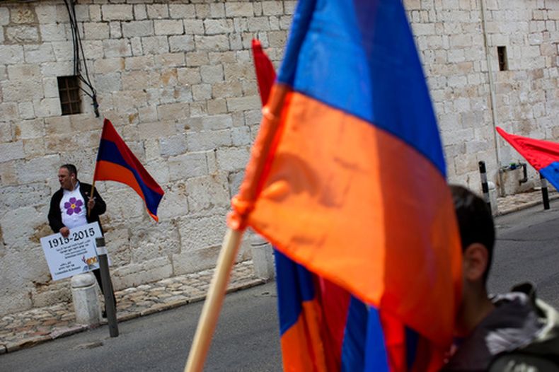 ARCHIVO - Armenios sostienen su bandera nacional durante una ceremonia para conmemorar el asesinato masivo de armenios por parte del Imperio Otomano, en Jerusalén, Israel, el viernes 24 de abril de 2015. (AP Foto/Oded Balilty, Archivo)