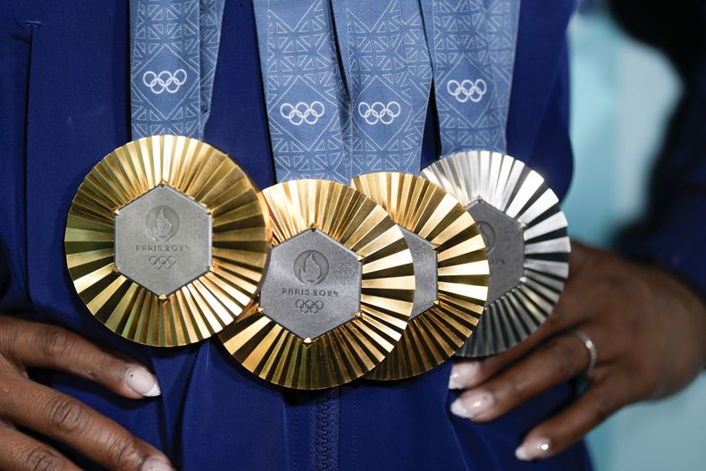 ARCHIVO - Simone Biles, de Estados Unidos, sostiene sus medallas después de la final de aparatos individuales de gimnasia artística femenina en el Bercy Arena en los Juegos Olímpicos de Verano de 2024, el lunes 5 de agosto de 2024, en París, Francia. (AP Foto/Charlie Riedel, Archivo)