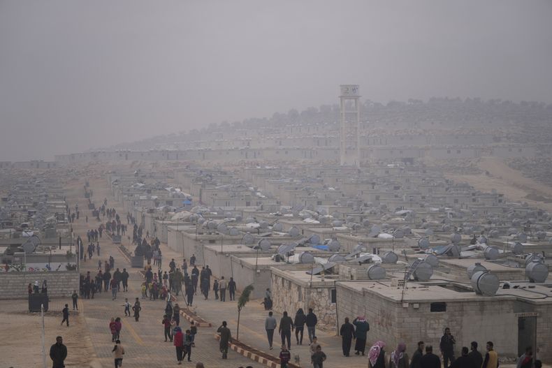 Sirios caminan en un campo de refugiados para desplazados dirigido por la Media Luna Roja de Turquía, el 26 de noviembre de 2021, en el distrito de Sarmada, al norte de la ciudad de Idlib, Siria. (AP Foto/Francisco Seco, archivo)