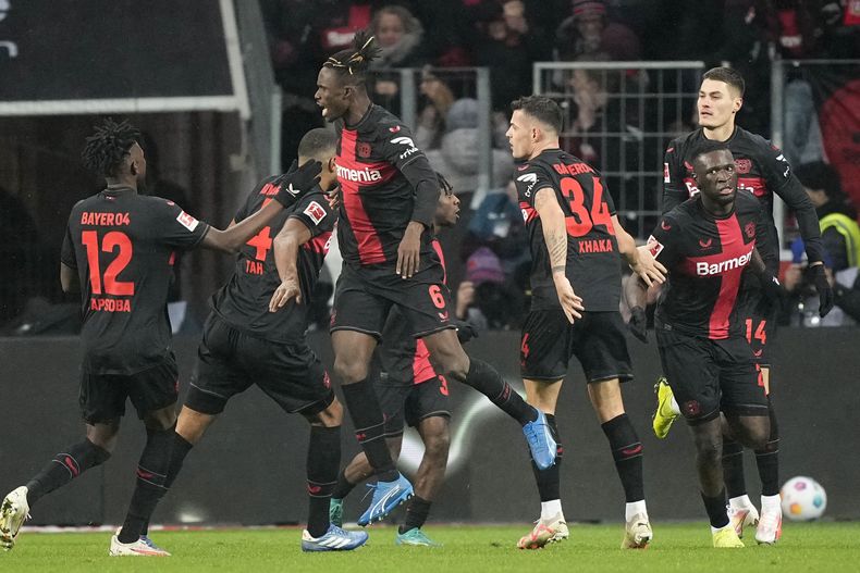 Victor Boniface del Bayern Leverkusen celebra con sus compañeros tras anotar el gol de su equipo en el encuentro de la Bundesliga ante el Borussia Dortmund el domingo 3 de diciembre del 2023. (AP Foto/Martin Meissner)