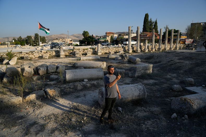 ARCHIVO – Un visitante palestino toma una foto en el sitio romano histórico en la ciudad de Sebastia, en Cisjordania, el jueves 20 de noviembre de 2025. (AP Foto/Nasser Nasser, Archivo)