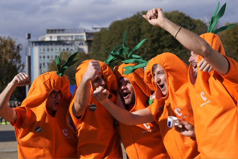 El grupo de seguridad del tenista italiano Jannik Sinner autodenominados Carota Boys alientan afuera del Pala Alpitour antes de encuentro del italiano ante Stefanos Tsitsipas en las Finales de la ATP el domingo 12 de noviembre del 2023. (AP Foto/Antonio Calanni)