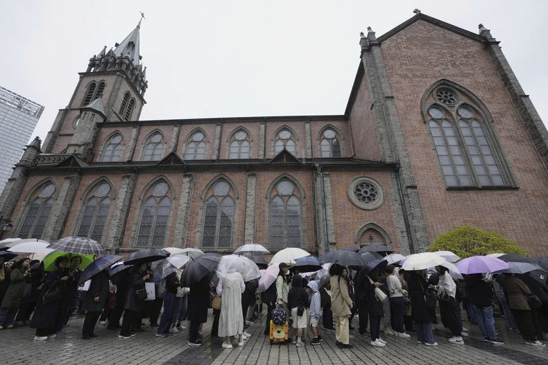 Un grupo de personas esperan en fila para entrar a la catedral de Myeongdong para rendir homenaje al difunto papa Francisco, en Seúl, Corea del Sur, el 22 de abril de 2025. (AP Foto/Ahn Young-joon)