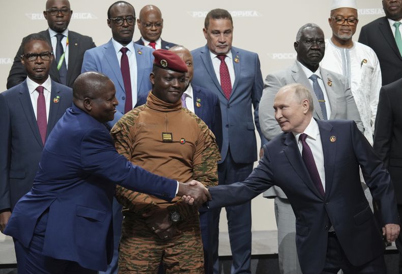 El presidente ruso Vladímir Putin, derecha, y el mandatario de Mozambique, Filipe Nyusi, se estrechan la mano durante la cumbre Rusia-África el viernes 28 de julio de 2023, en San Petersburgo, Rusia. (Alexei Danichev, Sputnik, foto compartida por el Kremlin vía AP)