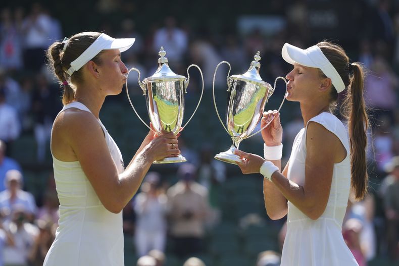 Veronika Kudermetova de Rusia, a la derecha, y Elise Mertens de Bélgica celebran con los trofeos tras ganar contra Jelena Ostapenko de Letonia y Su-Weih Hsieh de Taiwán su partido de final de dobles femeninos en el Campeonato de Tenis de Wimbledon en Londres, el domingo 13 de julio de 2025. (AP Photo/Kirsty Wigglesworth)