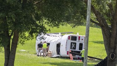 Policía y socorristas inspeccionan un autobús que se volcó tras chocar con una camioneta matando a ocho de 50 jornaleros que iban en el camión, el 14 de mayo de 2024, en Ocala, Florida. (Foto AP/Alan Youngblood)