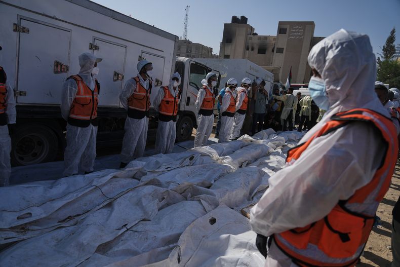 Los restos de palestinos no identificados, devueltos por Israel como parte de un acuerdo de alto el fuego, son preparados para un funeral multitudinario frente al Hospital Nasser en Jan Yunis, en la Franja de Gaza, el miércoles 22 de octubre de 2025. (Foto AP/Jehad Alshrafi)