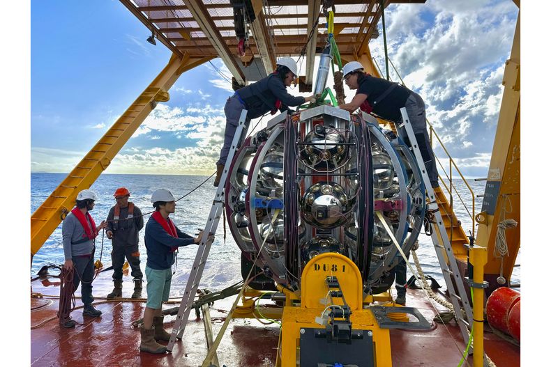 Científicos se preparan para bajar un equipo usado para detectar neutrinos en el Mar Mediterráneo. (Paschal Coyle, KM3NeT via AP)