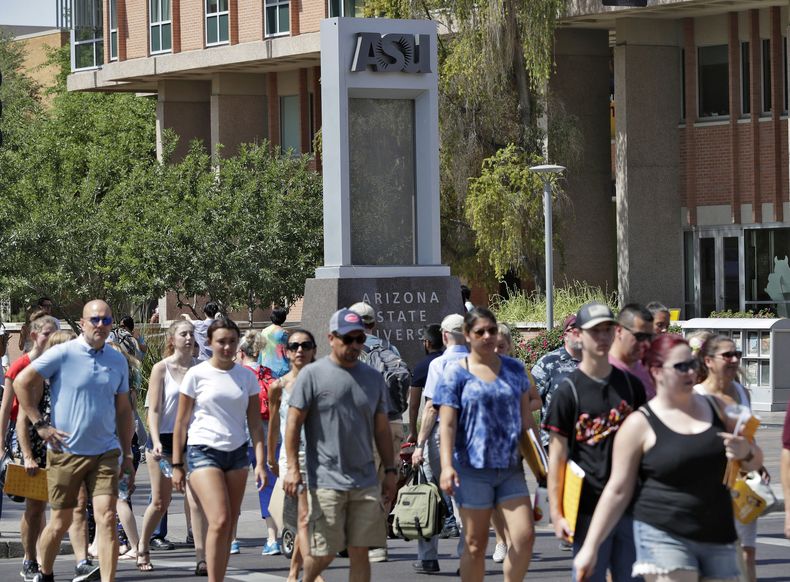 Peatones cruzan una calle en el campus de la Universidad Estatal de Arizona, el 25 de julio de 2018, en Tempe, Arizona. (AP Foto/Matt York, Archivo)