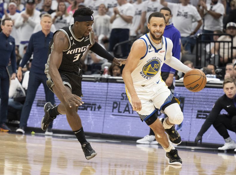 Stephen Curry de los Warriors de Golden State frente a Terence Davis de los Kings de Sacramento, el domingo 30 de abril de 2023, en Sacramento, California. (AP Foto/José Luis Villegas)