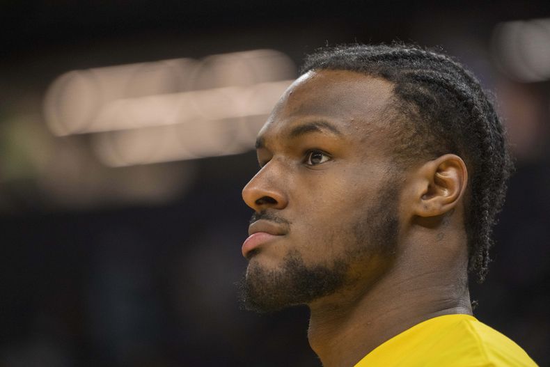 El armador de los Lakers de Los Ángeles, Bronny James observa la actividad del calentamiento previo al juego de la Liga de Verano de la NBA ante los Warriors de Golden State, en San Francisco, el domingo 7 de julio de 2024. (AP Foto/Nic Coury)
