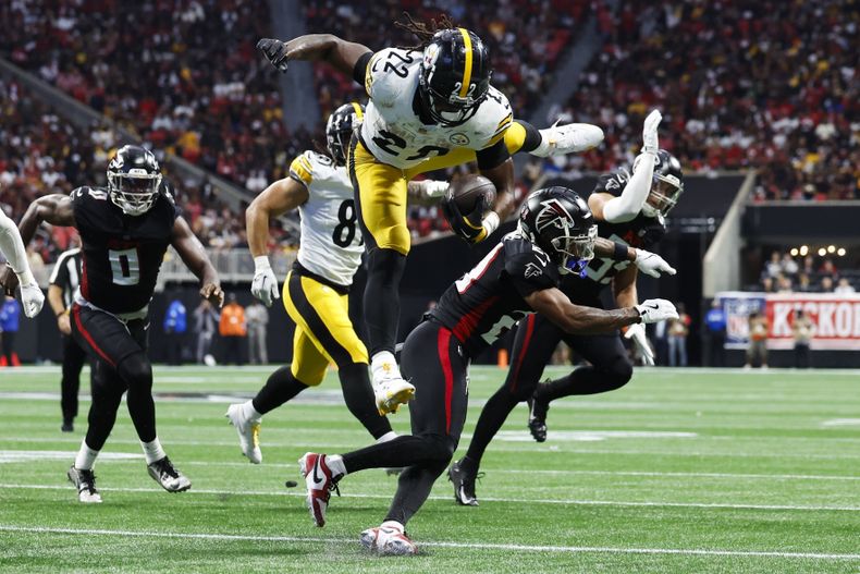 El running back Najee Harris (22), de los Steelers de Pittsburgh, brinca sobre el cornerback Mike Hughes (21), de los Falcons de Atlanta, durante la segunda mitad del partido de la NFL del domingo 8 de septiembre de 2024, en Atlanta. (AP Foto/Butch Dill)