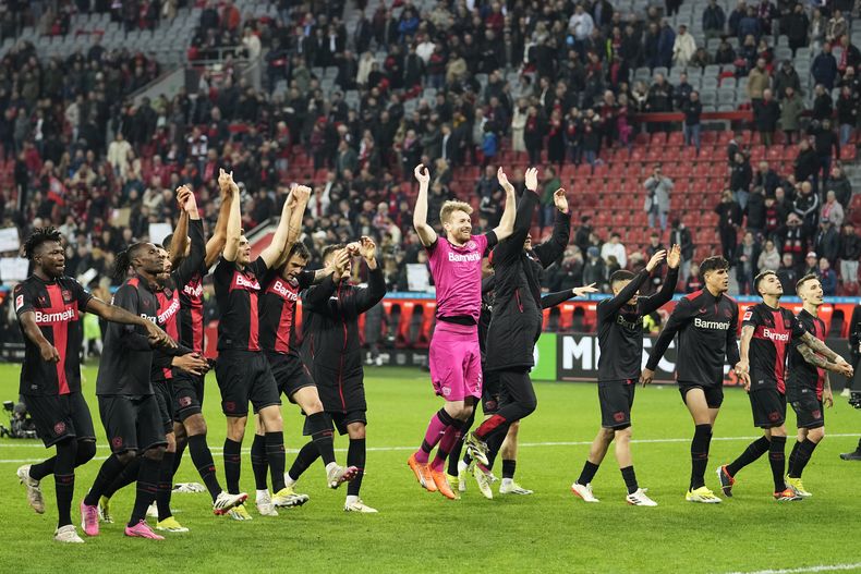 Jugadores del Leverkusen celebran después de su victoria en la Bundesliga de Alemanie en el juego de fútbol entre Bayer Leverkusen y VfL Wolfsburgo en la BayArena en Leverkusen, Alemania, el domingo 10 de marzo de 2024. (AP Foto/Martin Meissner)