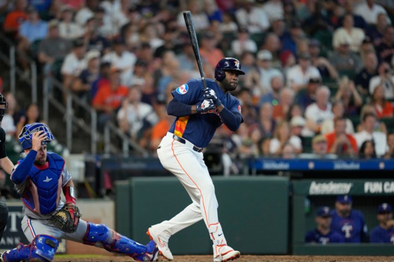 Yordan Alvarez, de los Astros de Houston (a la derecha), conecta un doblete impulsador de dos carreras mientras el receptor de los Rangers de Texas, Austin Wynns, observa durante la séptima entrada de un partido de béisbol el domingo 2 de agosto de 2026, en Houston. (Foto AP/David J. Phillip)